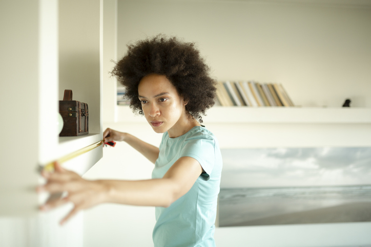 Female interior designer taking measurements at home woman measuring home