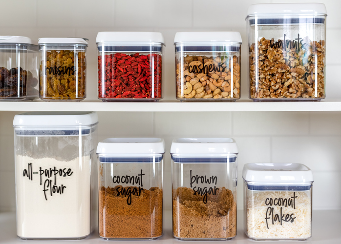 Neatly organized transparent canisters for baking ingredients Labeled canisters in kitchen pantry